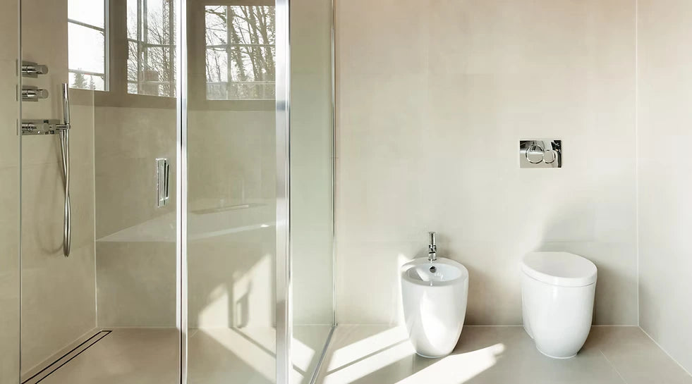 A light-filled tiled bathroom with a linear drain along the shower wall